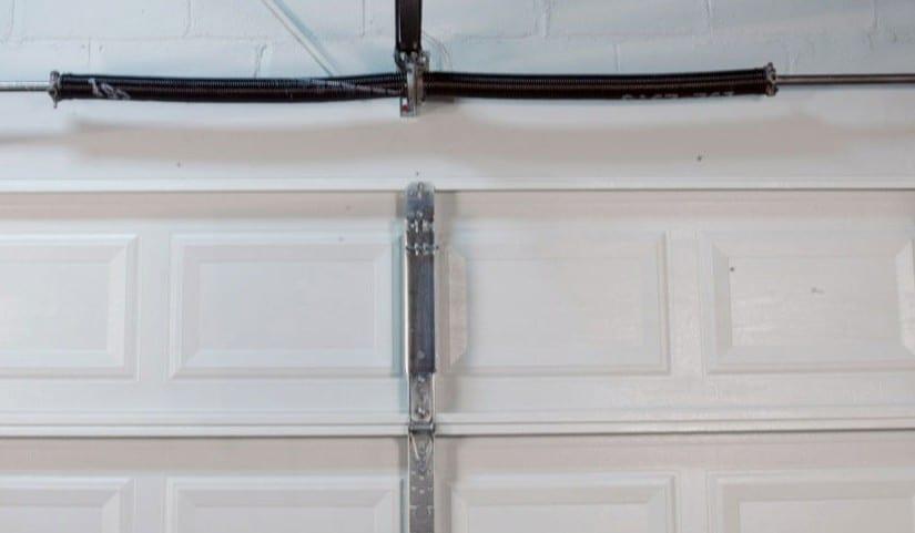 Torsion spring above garage door opening